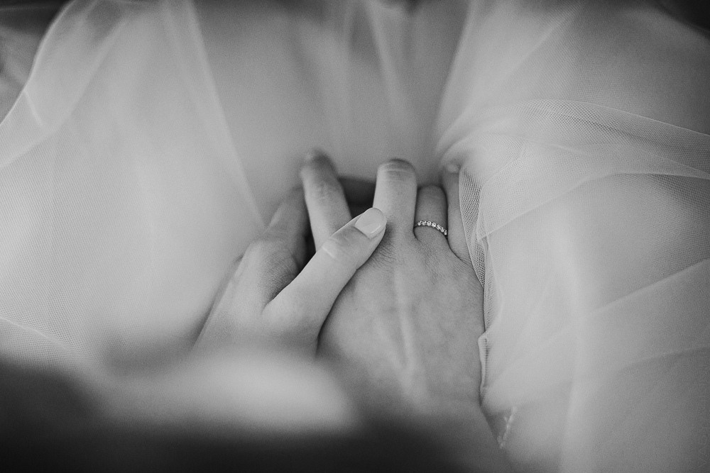 Молодожены идут по аллее с пышными деревьями и фонтанами, освещенными вечерним светом, на своей гламурной свадьбе в Ярославле