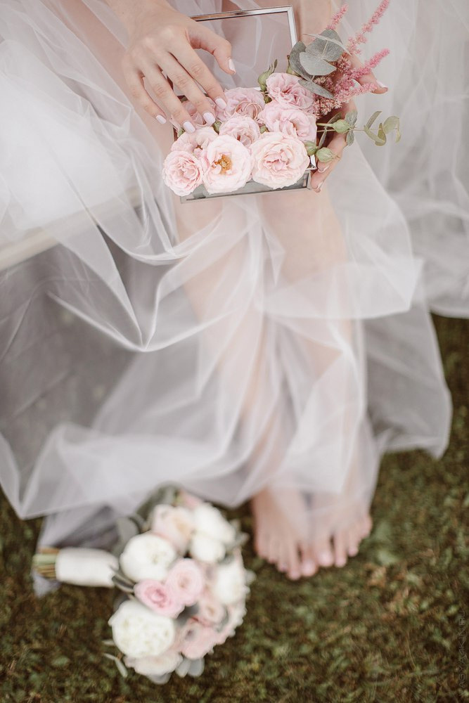 Фотография с гламурной свадьбы в Ярославле, где невеста и жених сидят в декоративной коляске, увитой цветочным венком