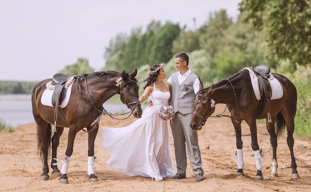 Невеста целует жениха на фоне красивого осеннего леса, где листья меняют свои цвета, создавая атмосферу тепла и уюта