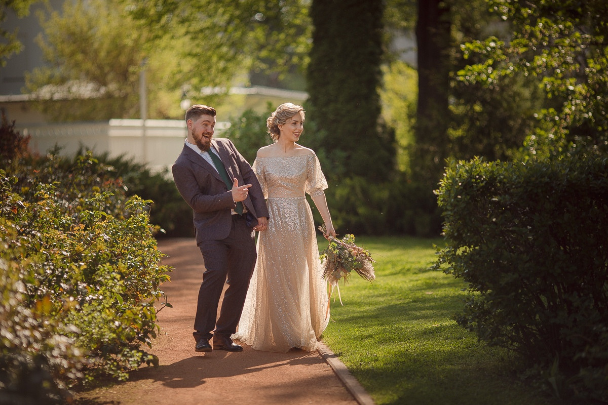 Свадебная фотография, на которой невеста и жених стоят на вершине горы, с восхитительным видом на окружающую природу