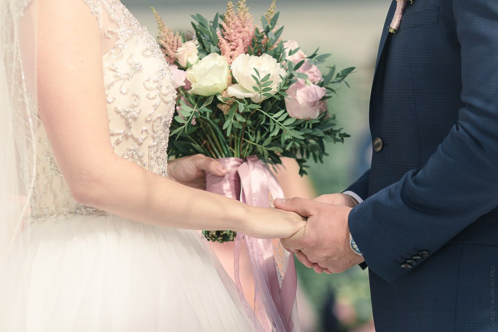 Новобрачные пьют горячий шоколад в открытой избушке на фоне снежных гор, создавая атмосферу уюта и тепла