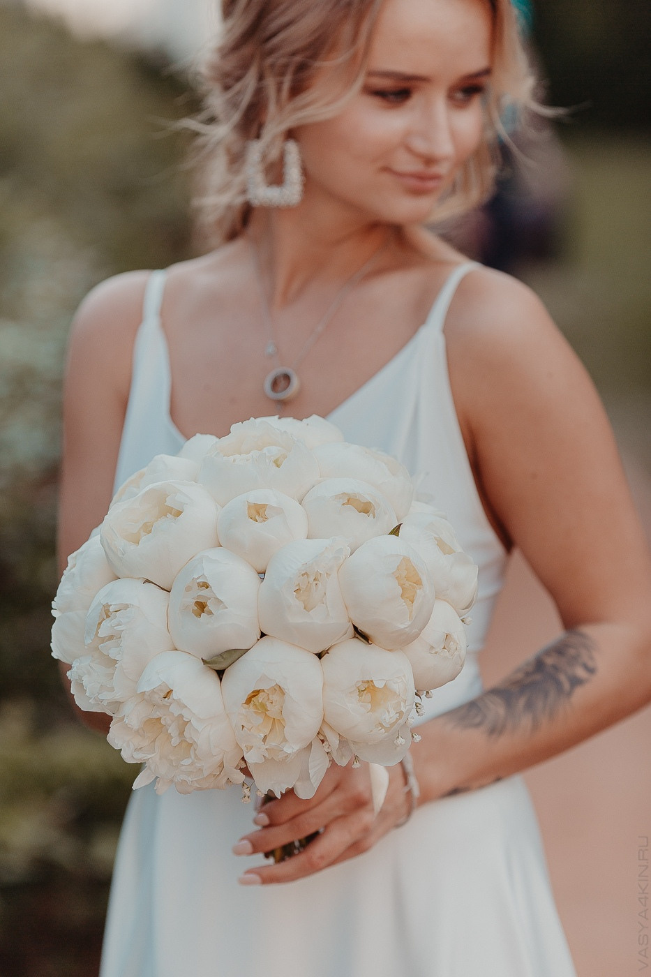 Фотография с гламурной свадьбы в Ярославле, где невеста стоит на дорожке, украшенной белыми розами и лентами, перед входом в свадебное помещение