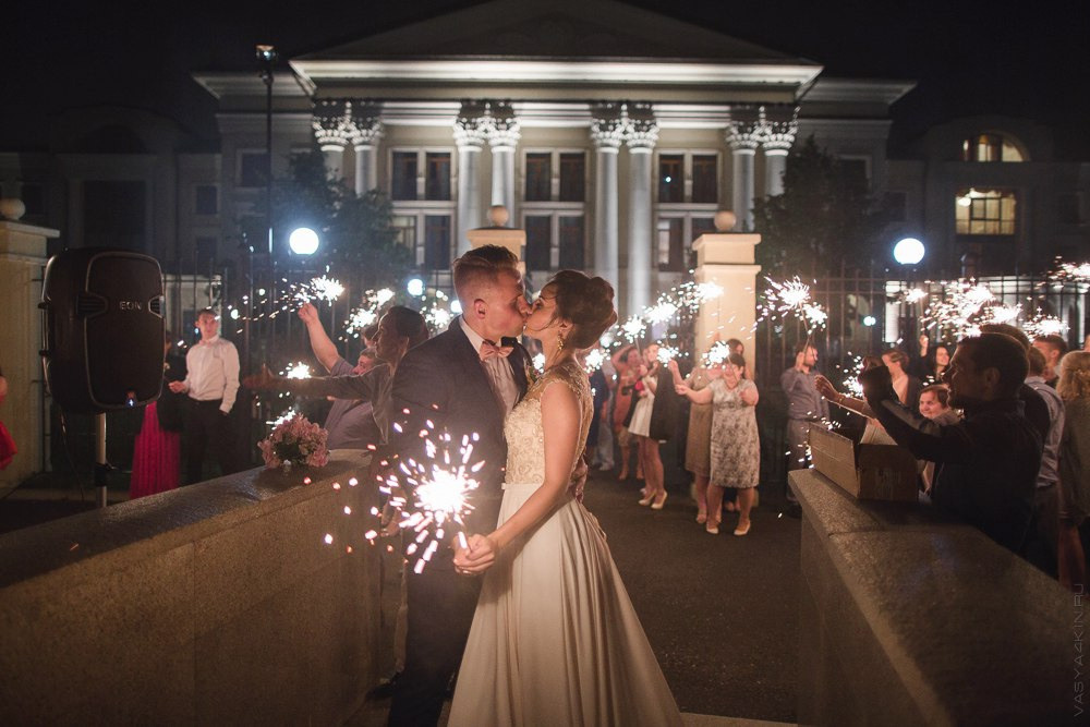 Невеста и жених сутулятся под одним зонтом, создавая понятие сопричастности и объединения их сил