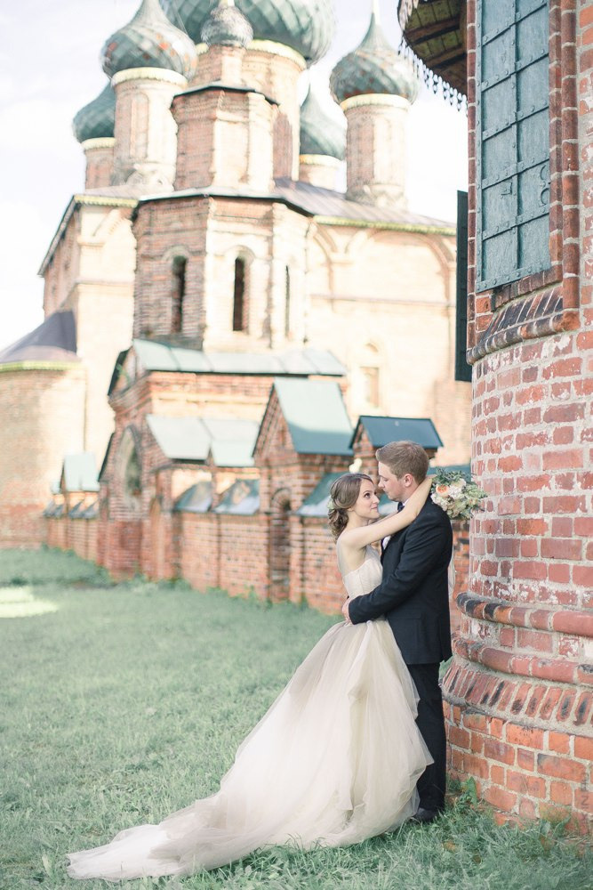 Поцелуй невесты на щеке жениха прекрасно запечатлен на этой фотографии, раскрывая глубину и искренность их чувств