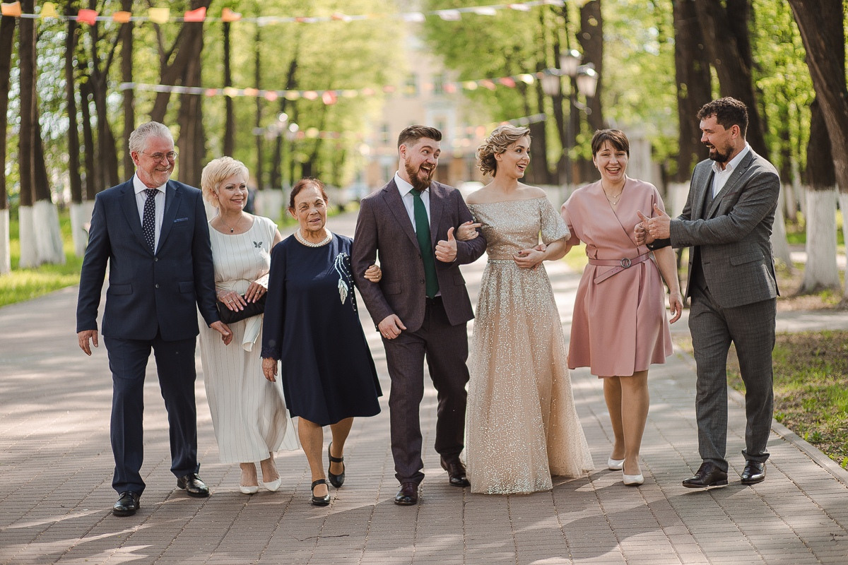 Невеста и жених держат в руках фонарики и прогуливаются по пляжу в вечернее время суток, создавая атмосферу тайны и романтики