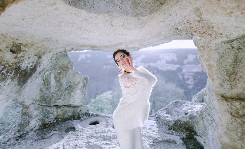 Молодожены в объятиях на свадебной фотографии среди зеленого луга