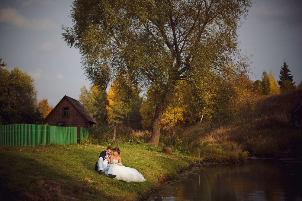 Ласковый поцелуй невесты в щеку ее избраннику на фоне роскошных цветов и украшений