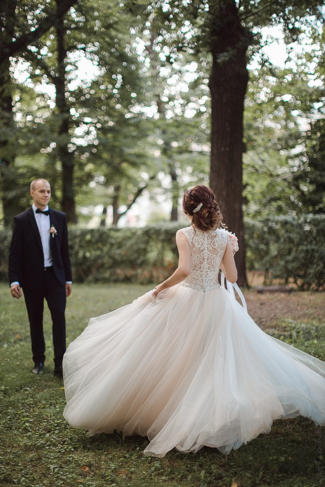 Снимок, на котором жених положил руку на талию невесты, и они вместе смотрят вдаль, создавая чувство солидарности и единства