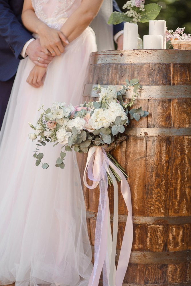 Невеста, держащая в руках подвеску с фотографией своих родителей в знак уважения к ним