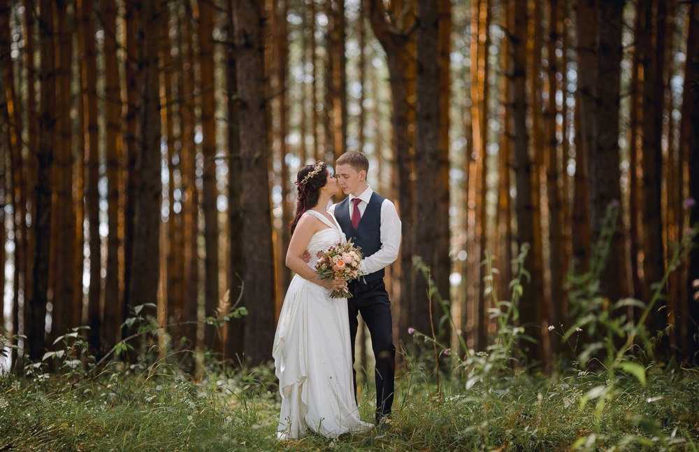 Улыбающаяся невеста, гуляющая под дождем с зонтиком в р