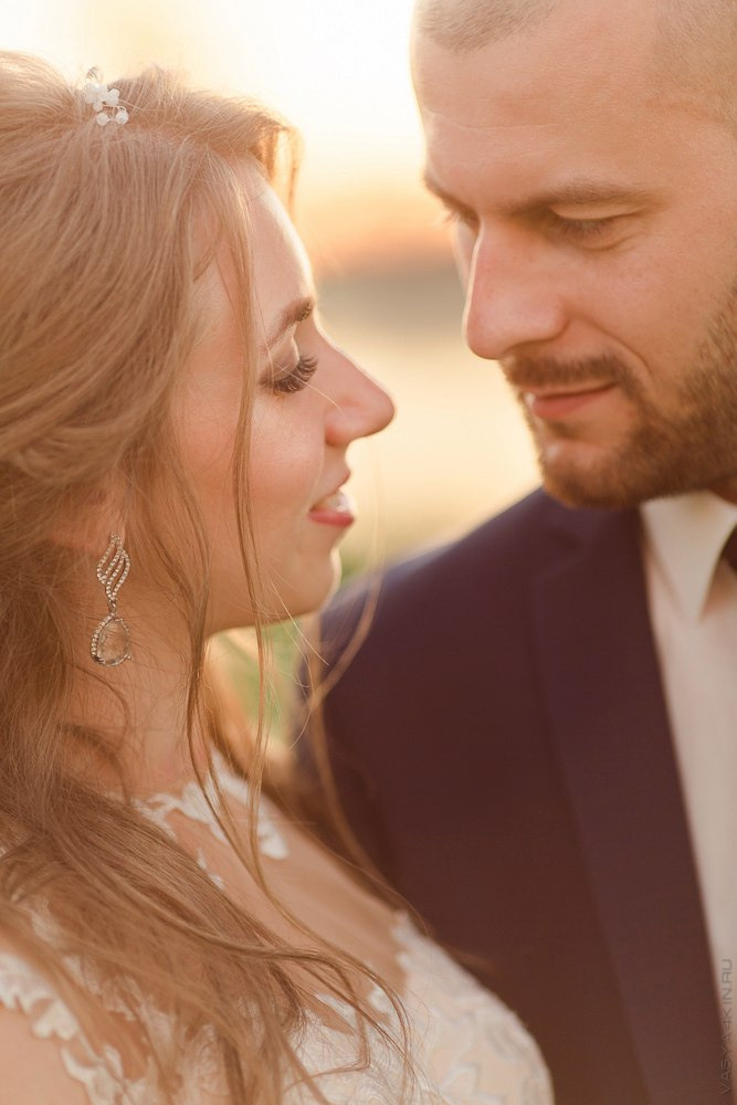 Пара, обнимающаяся на строительной лесенке, смотрящая на залитую солнцем площадку рядом с ними