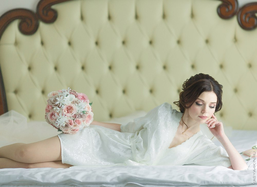 Невеста, с пышной фатой, нежно откинутой назад, выглядит образно и неповторимо