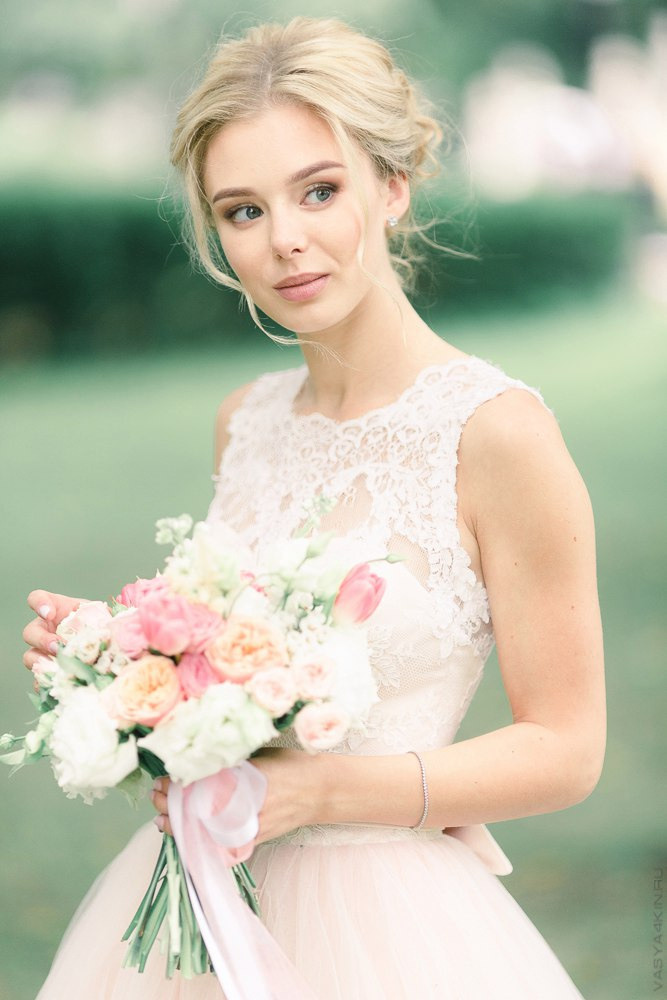 Невеста, надевающая свадебное платье, смотрищую в зеркало, когда вся ее красота видна другим