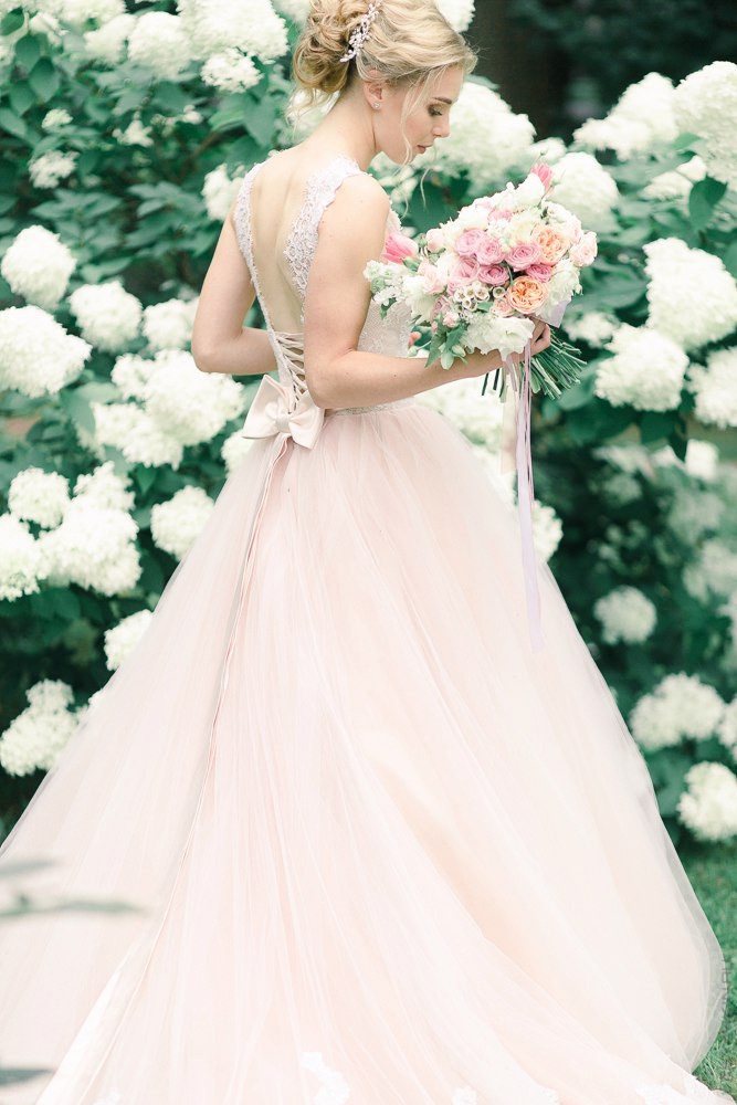 Фотография с гламурной свадьбы в Ярославле, где невеста стоит на дорожке, усыпанной белыми розами, перед входом в свадебное помещение