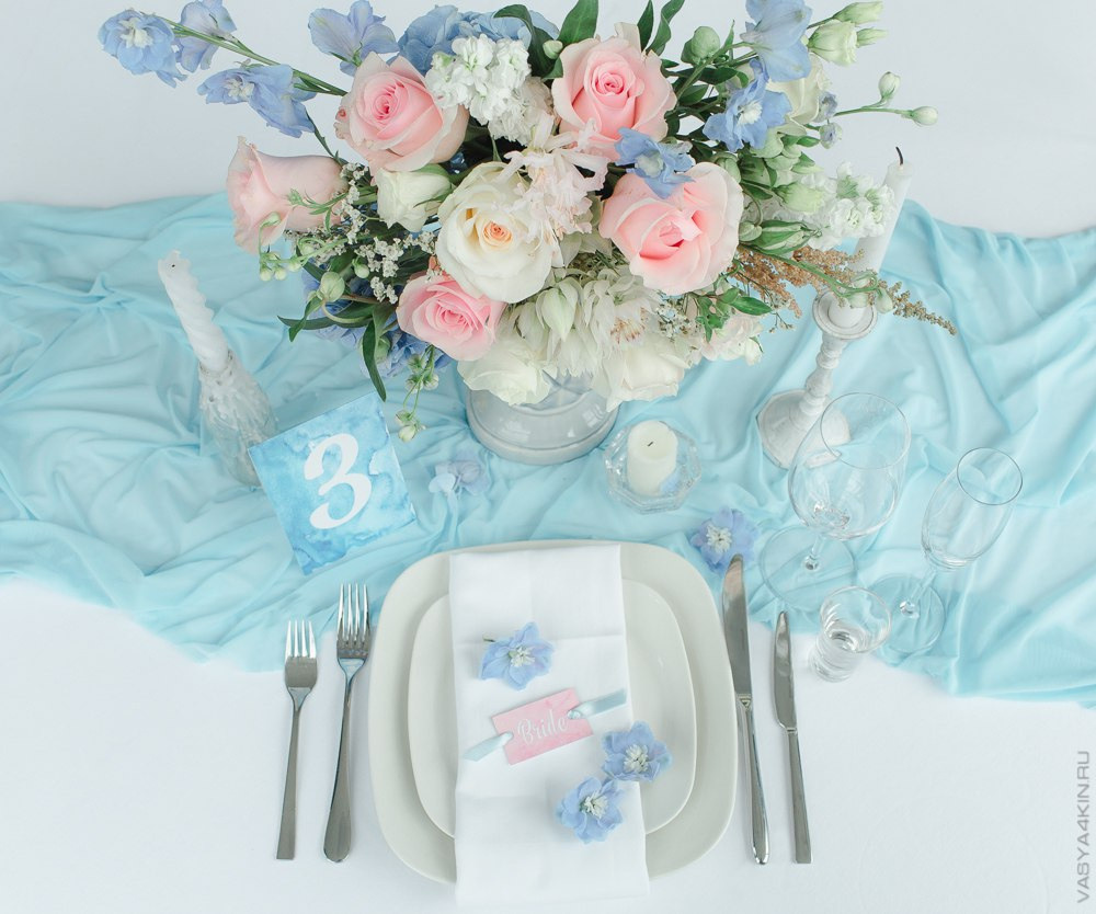 Невеста стоит на вершине холма в платье с длинным шлейфом, создавая ощущение величия и прекрасного