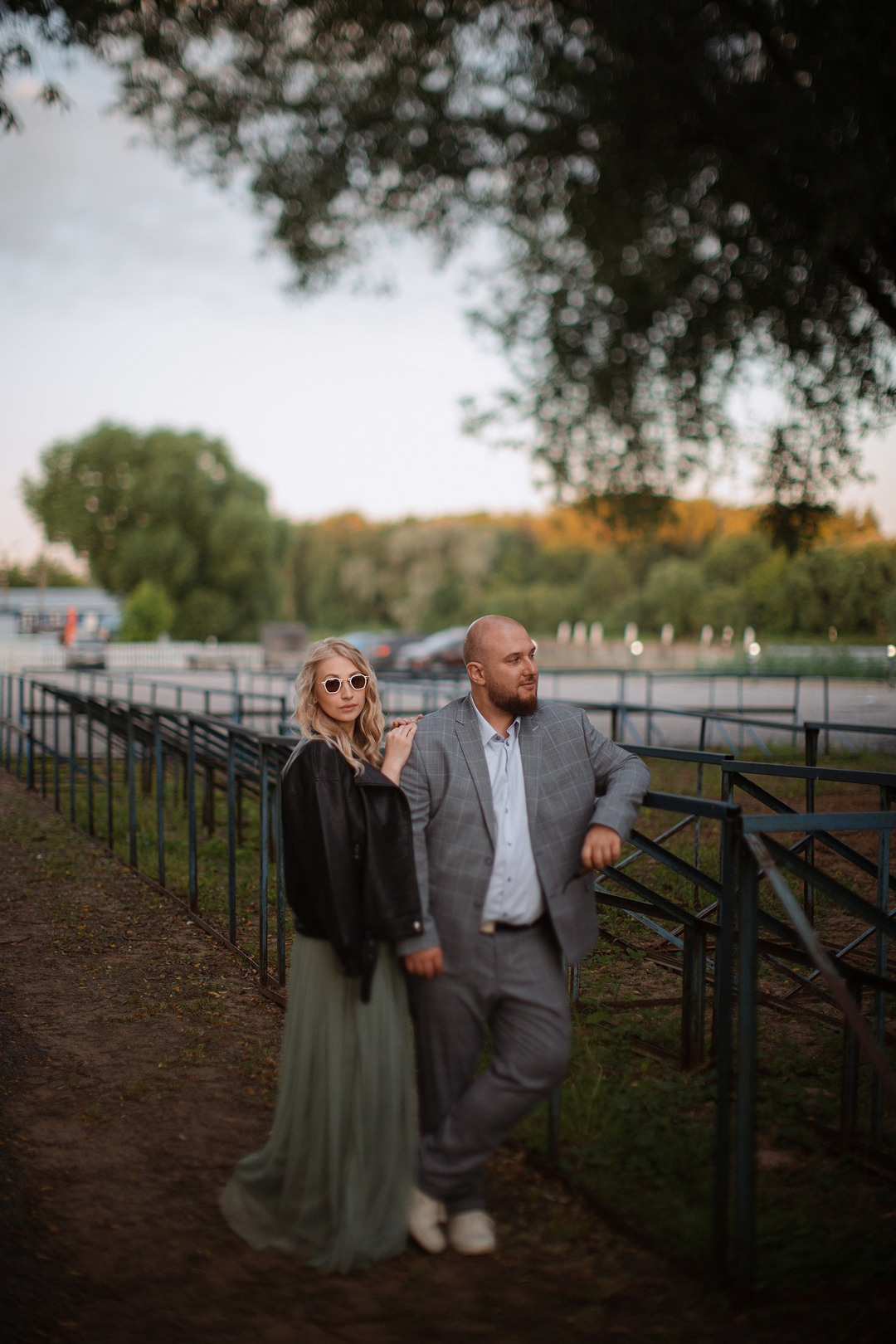 Невеста, сидящая на коленях молодого, смотрящего ей в глаза с яркой улыбкой