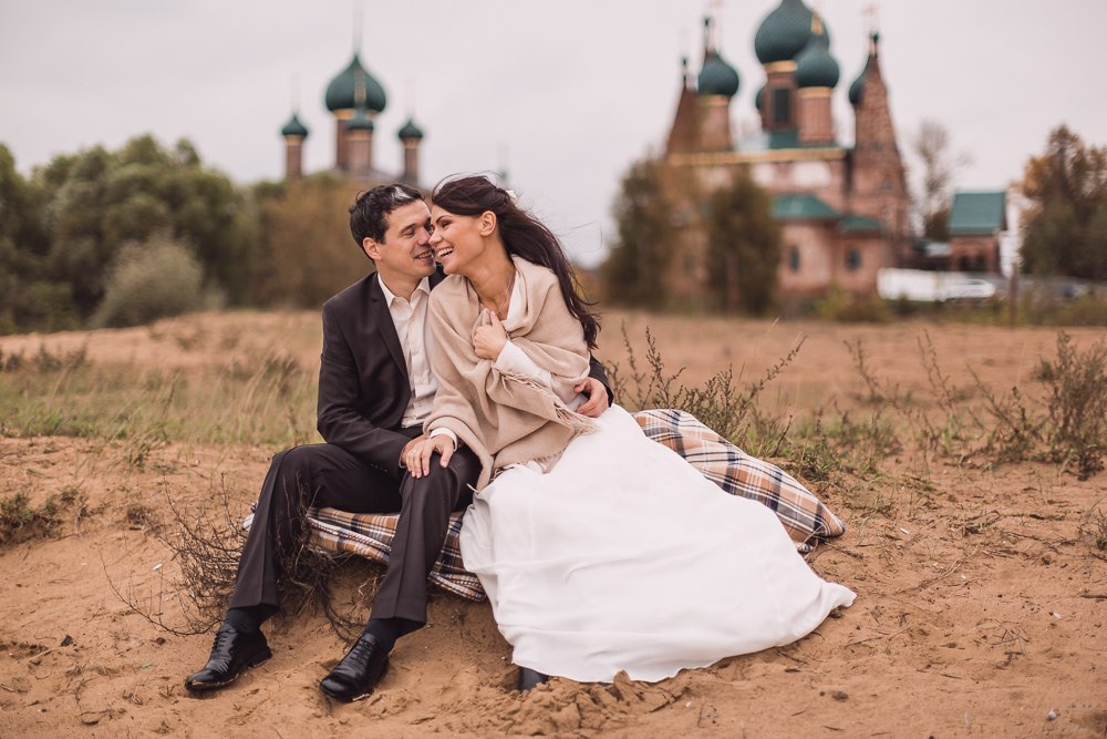 Молодые, целующиеся под огромным фонтаном, полным цветочных брызг, окружающих их