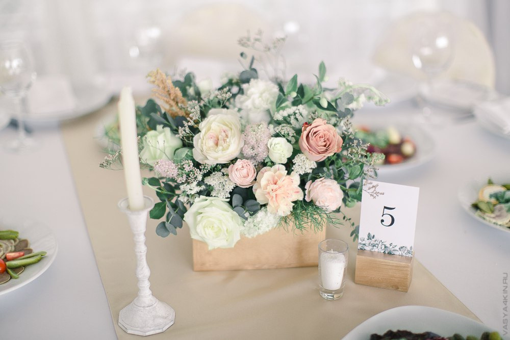 Молодая пара, стоящая на фоне украшенного фонтана с нежным сочетанием цветов и искусственного освещения