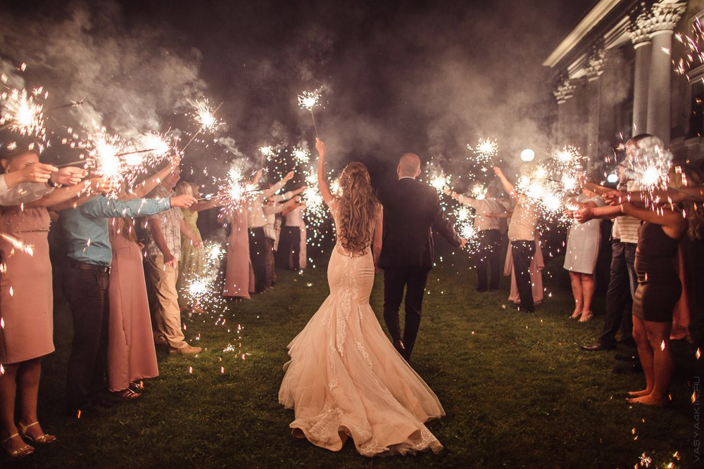 Невеста и жених идут по дорожке, украшенной светящимися шарами, на их роскошной свадьбе в Ярославле