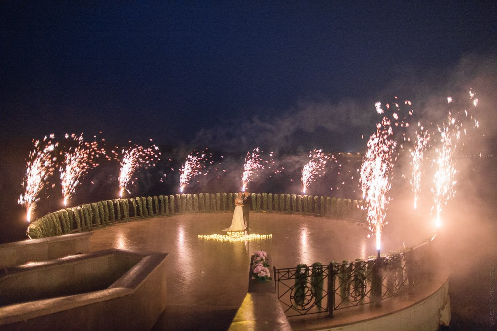 Молодежь, фотографирующаяся на фоне исторического здания, отпечатывающего настоящую атмосферу свадьбы