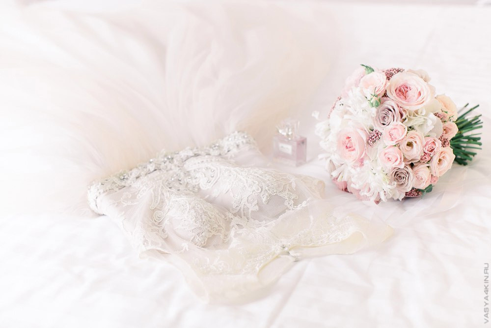 Невеста целует жениха на лбу с такой нежностью, что ее эмоции можно почувствовать на этой трогательной свадебной фотографии