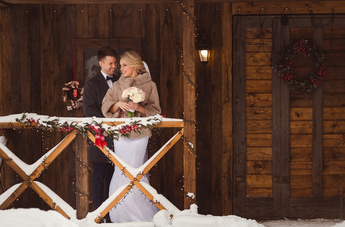 Молодые, стоящие босиком в море, окруженные исходящими лучами заката