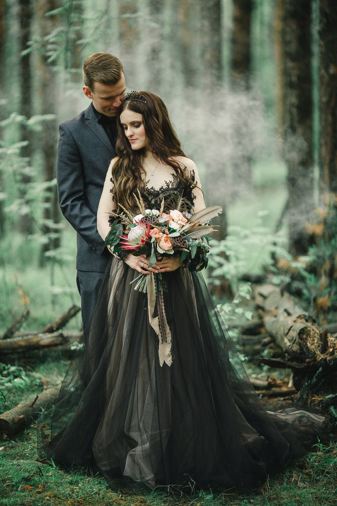 Невеста стоит на вершине холма, смотрящая на заходящее солнце, словно вся природа радуется их общему счастью на этой вдохновляющей свадебной фотографии