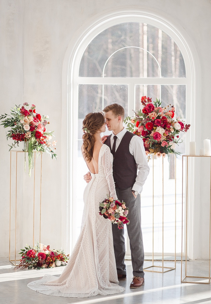 Влюбленная пара, сидящая под большим деревом, ствол которого покрыт вырезанными влюбленными сердцами