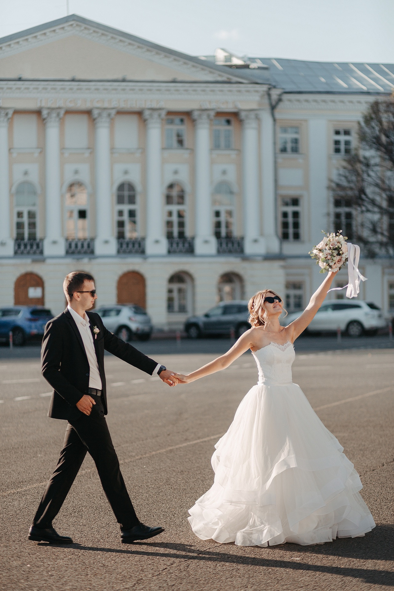 Фотография с гламурной свадьбы в Ярославле, где невеста стоит на дорожке, усыпанной белыми розами, перед входом в свадебное помещение