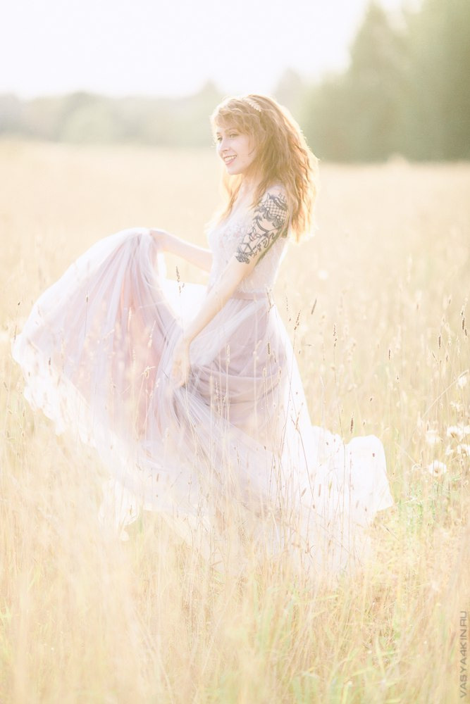 Молодые любовники, спрятавшись в сосновом лесу, целуются под световыми украшениями, повешенными на деревья