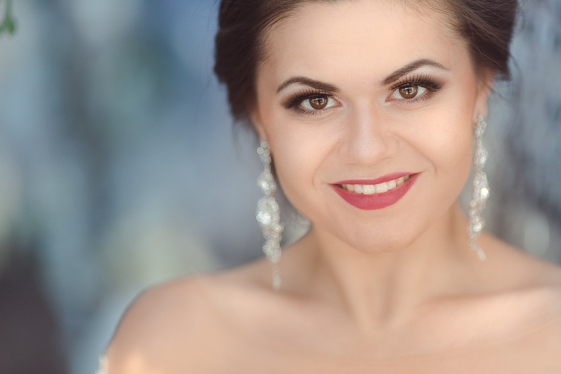 Снимок, на котором невеста и жених идут по аллее, усыпанной лепестками цветов, создающими атмосферу романтики и волшебства