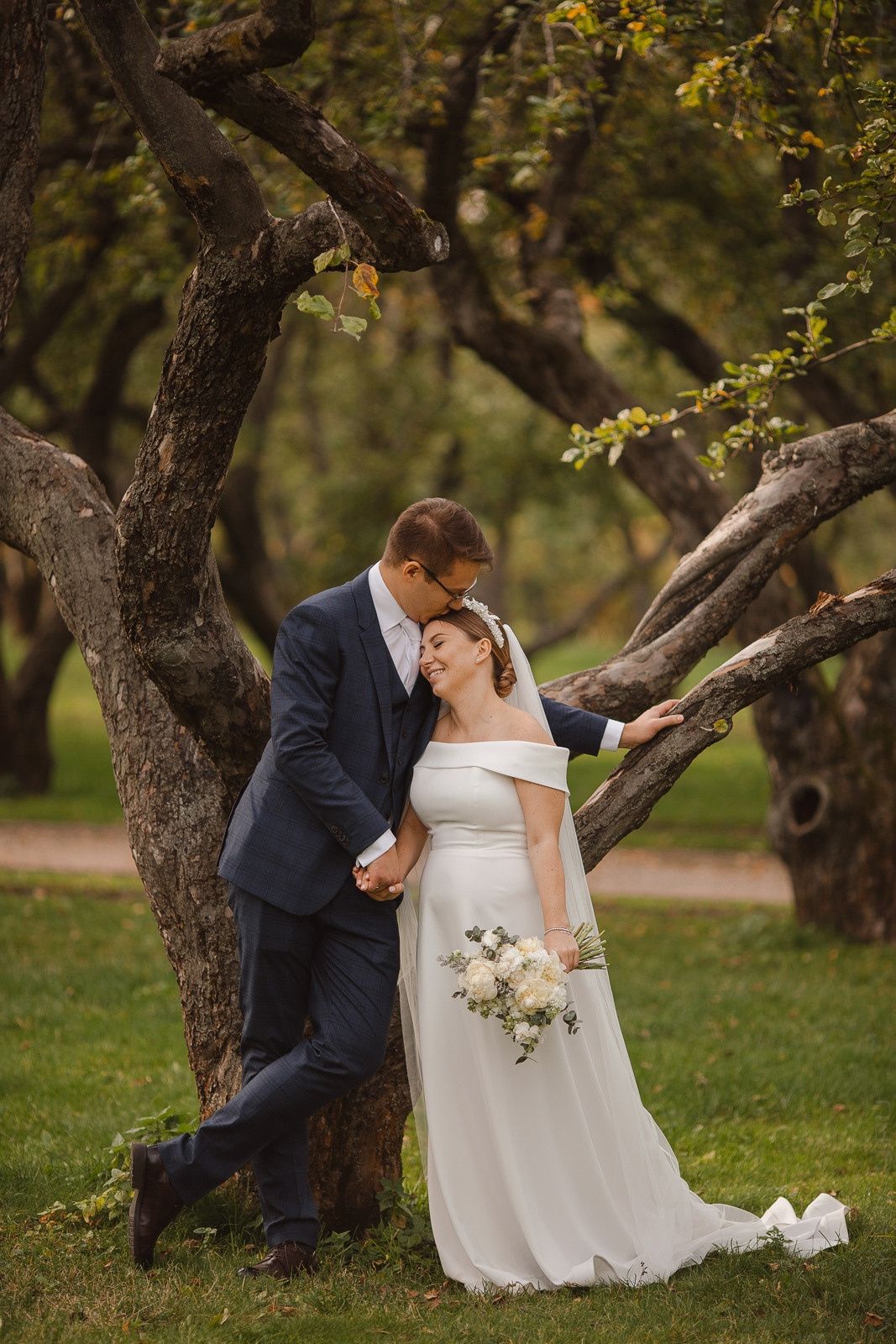 Свадебная фотография молодых, обнимающихся на фоне заснеженных деревьев