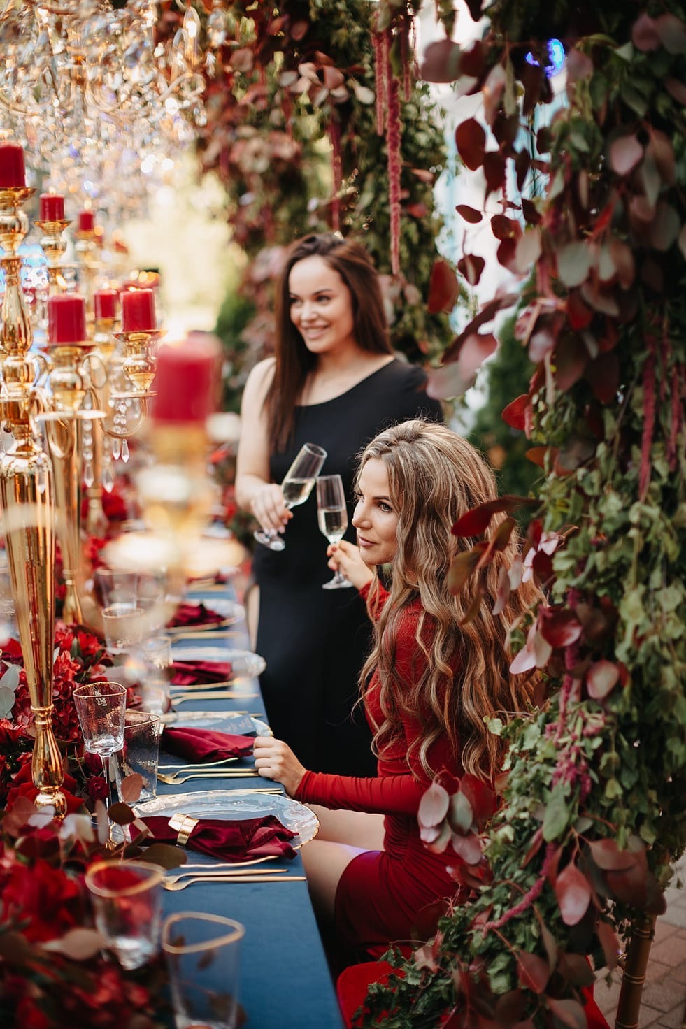 Жених, зажигающий воздушные фонарики, а его невеста, радостно смотря, улыбается и целует его на фоне темного неба