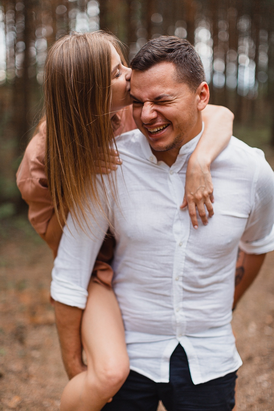 Молодые жених и невеста целуются на гребне белого песчаного холма, покрытого зеленью и морским бризом