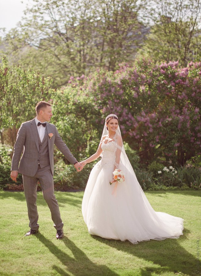 Невеста и жених идут по улочке с руку в руку, под роскошным цветочным ковром, словно исполняют свою сказку