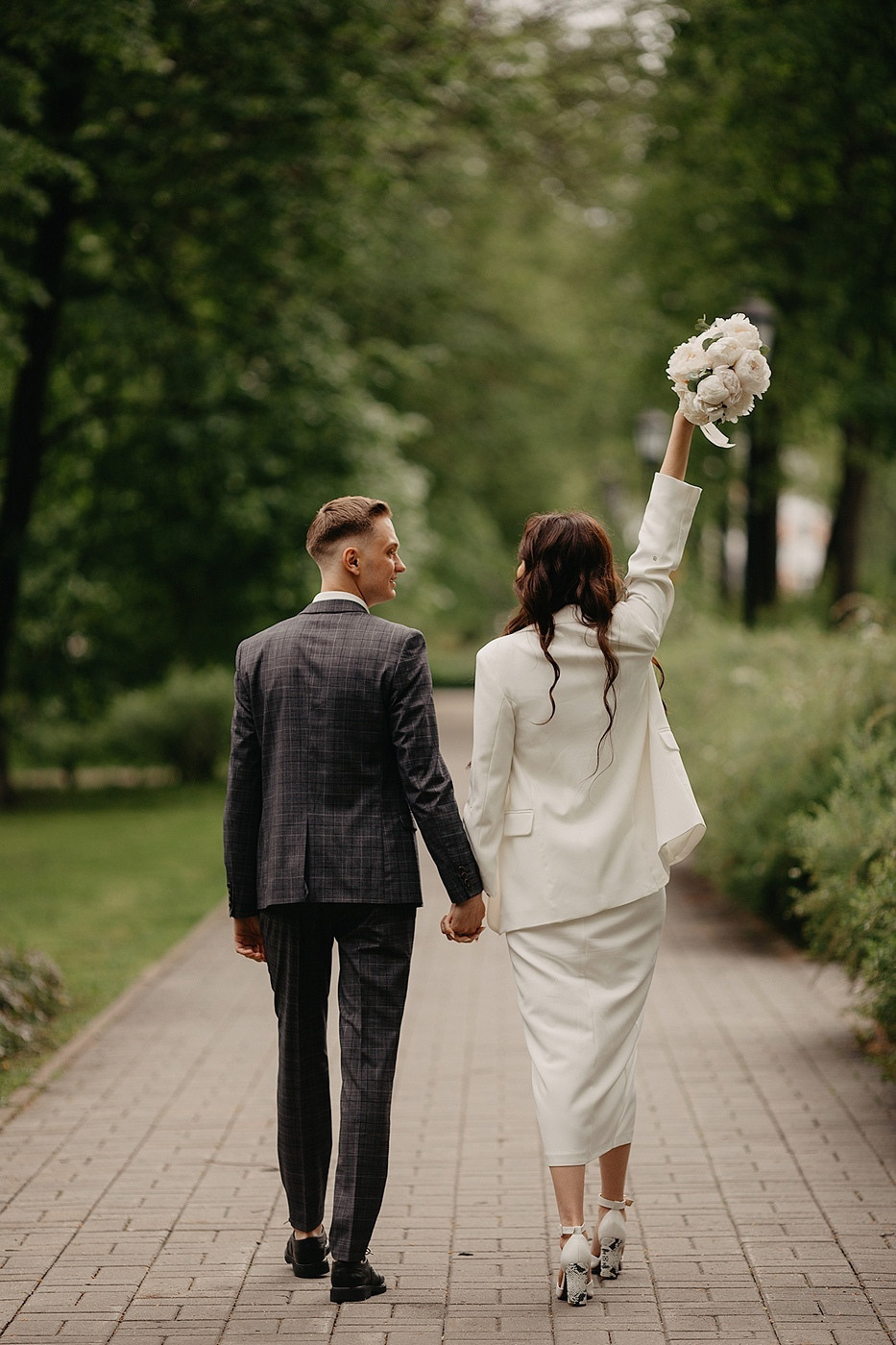 Фотография демонстрирует изысканную свадебную арку, увенчанную цветами, которая находится на дороге к свадебному залу