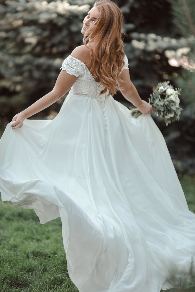 Молодожены, целующиеся во время дождя, вокруг них брызжет вода, отражаясь в ярких каплях на их коже