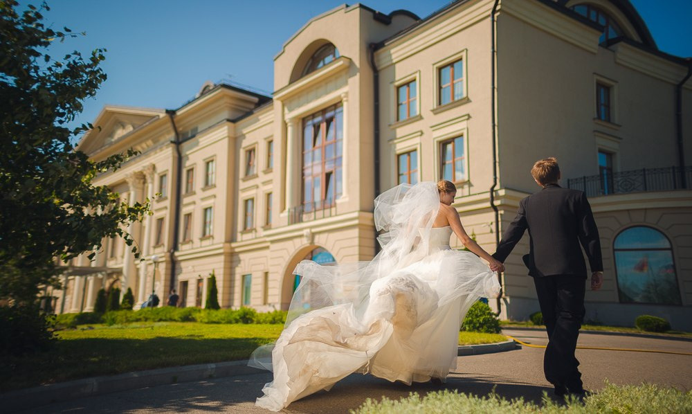 Снимок, на котором невеста и жених качаются на качелях, смеясь и наслаждаясь моментом