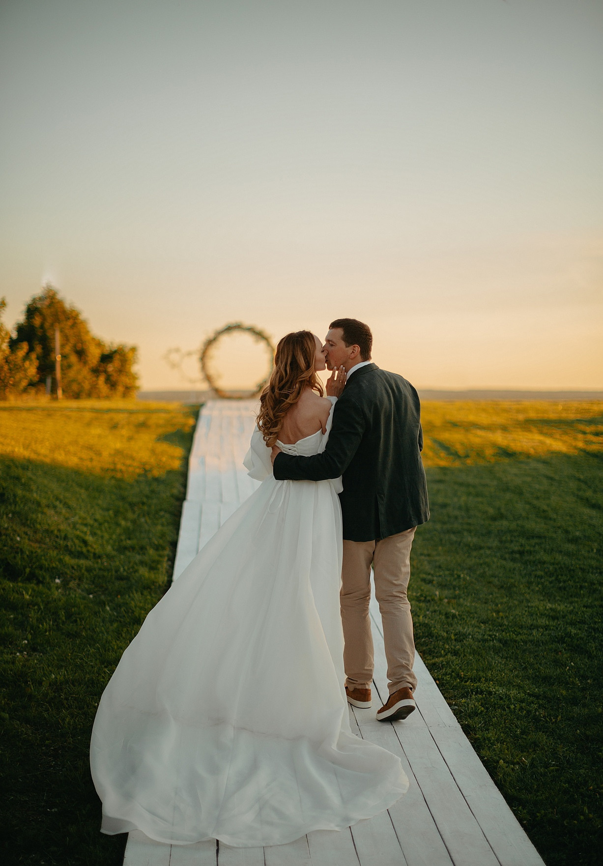 Одна молодая пара смотрит на другую, с сопровождающими родственниками, которые танцуют вокруг них