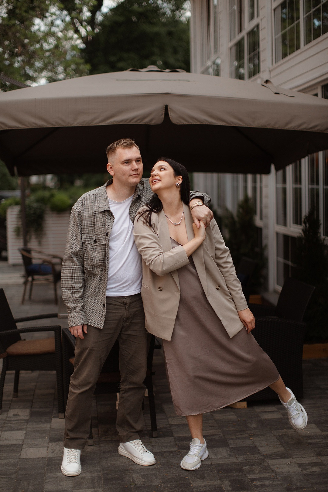 Невеста стоит на лужайке в своем изысканном платье свадьбы, словно его взмахами создает магию на этой свадебной фотографии