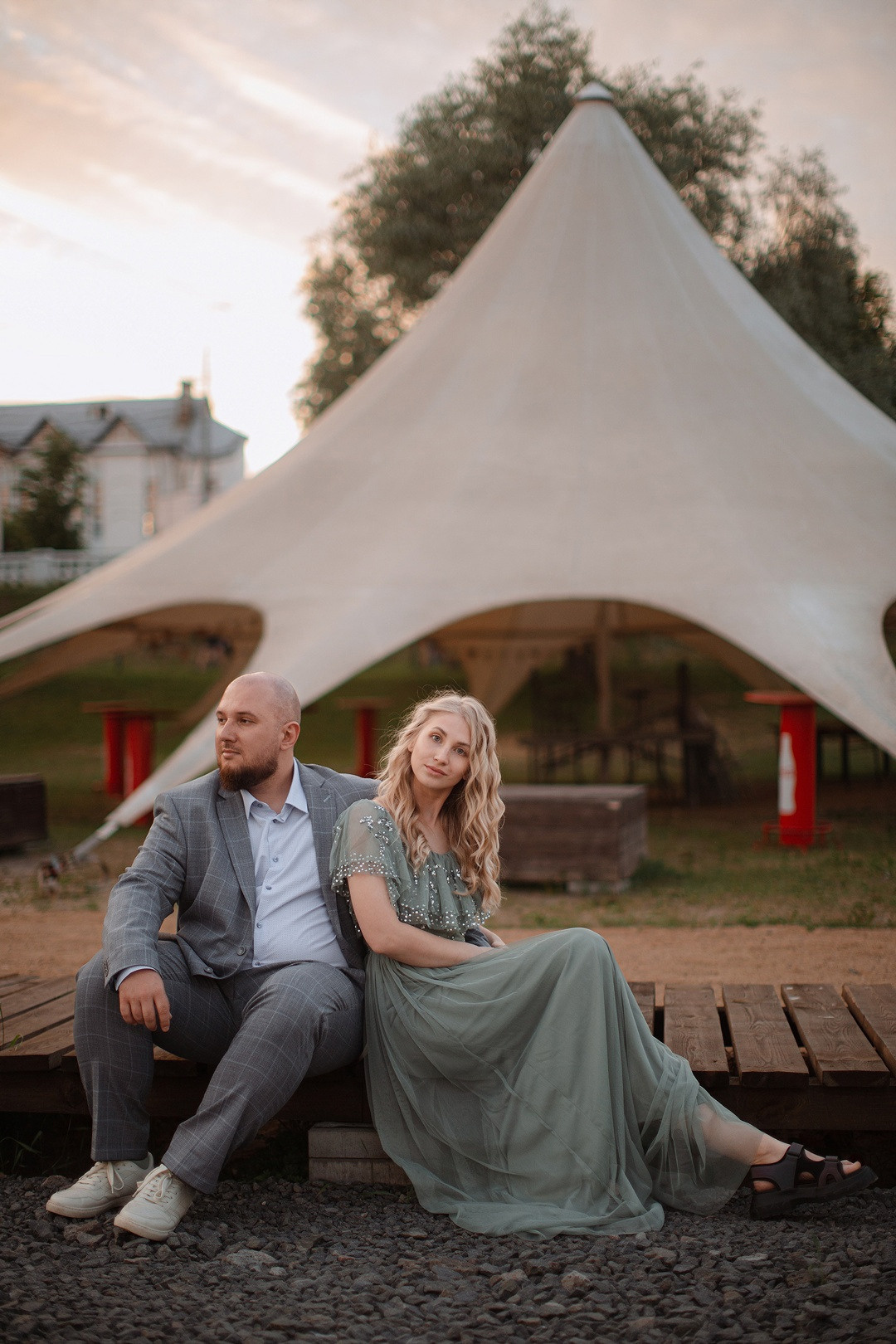 Пара стоит на фоне заходящего солнца, объятиями раскрывая свою нежность и силу любви