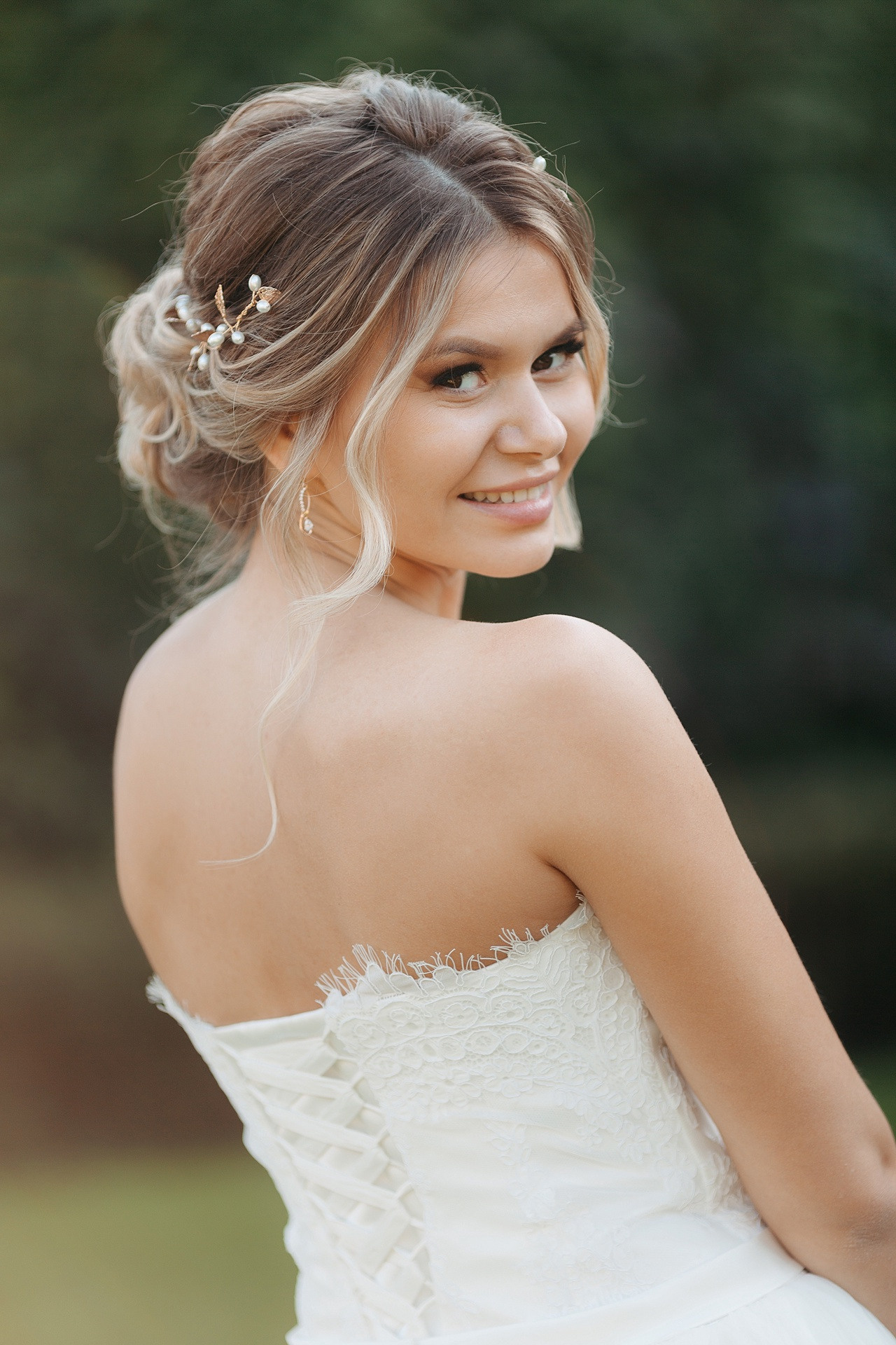 Невеста, стоящая под подсвечиваемым нежным шарфом, создающим образ романтики