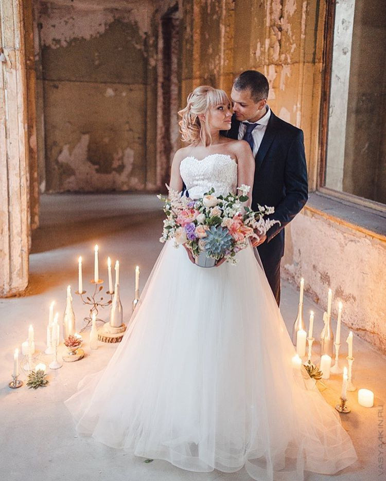 Семейная фотография, изображающая молодоженов с родителями и бабушками, создающая образ теплоты и единства