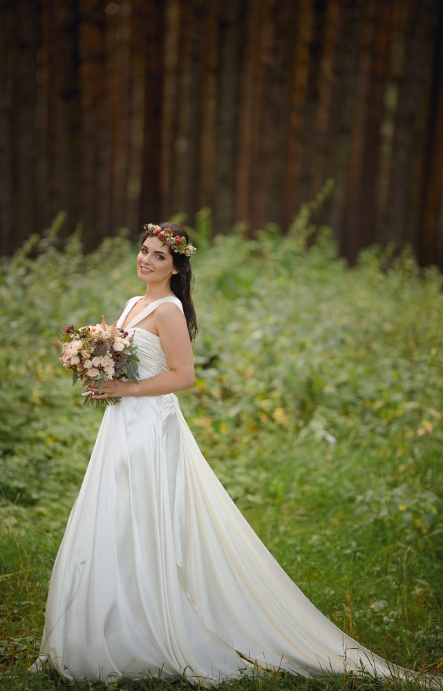 Пара, целующаяся на лавочке в красивом парке, где ветка дерева нежно прикасается к их плечу