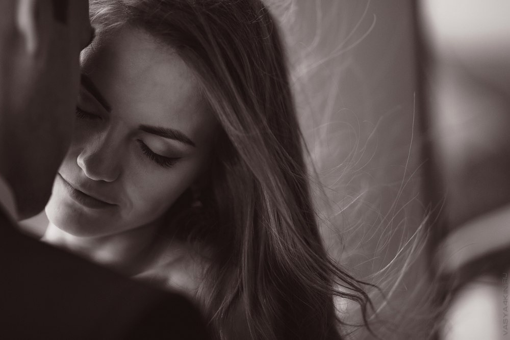 Молодая пара, сидящая на скамейке в старинном городе, которая оживает за их спиной