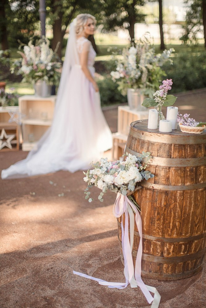 Пара целуется на фоне неба, словно они начинают свое путешествие по облакам на этой романтической свадебной фотографии