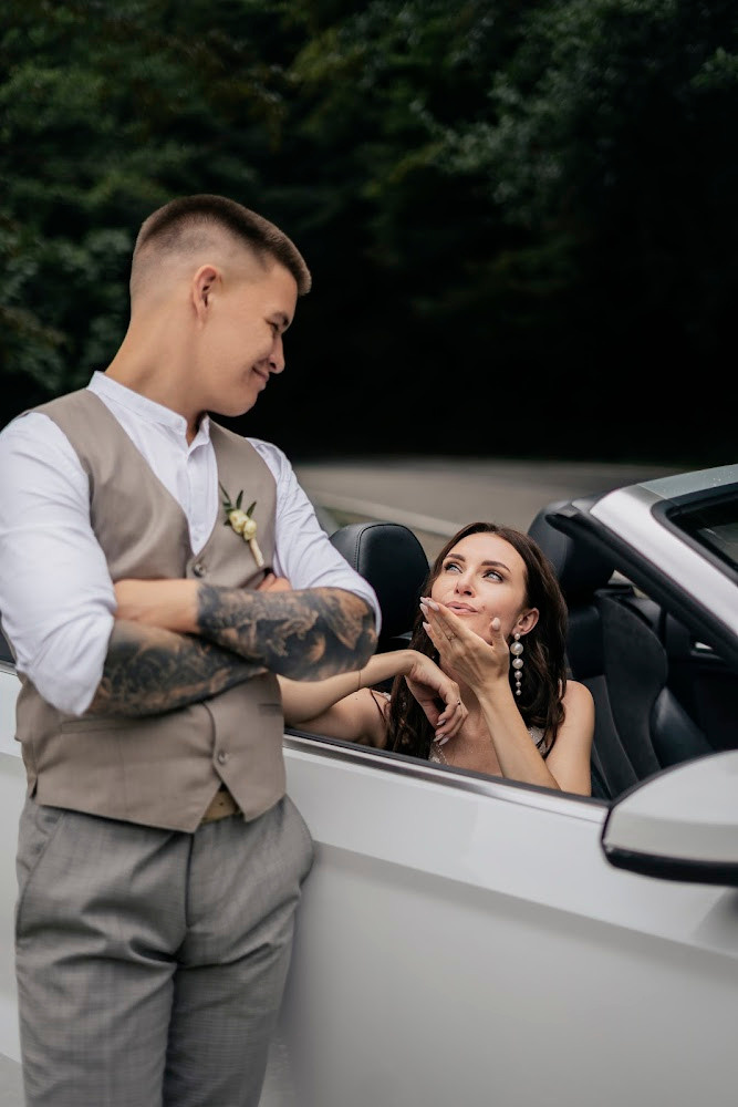 Невеста шлет воздушный поцелуй из окна кабриолета 