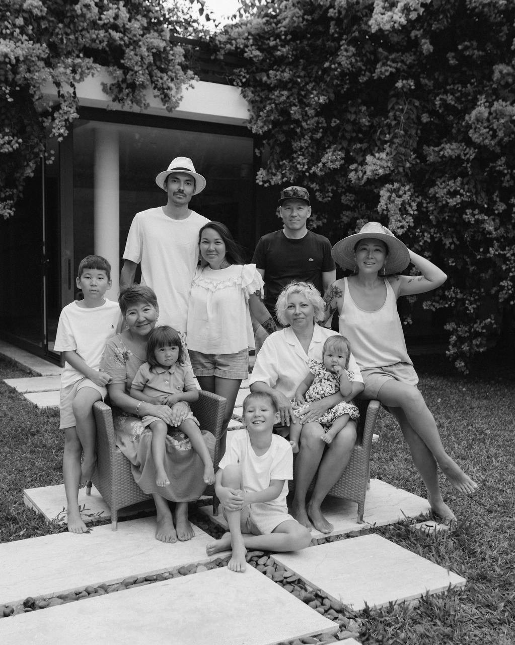 Семейное фото на улице: родители и дети сидят вместе, живые эмоции