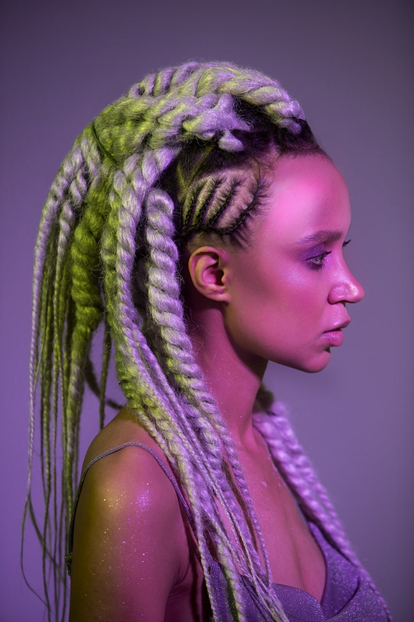 Космическая фотосъёмка девушки с зелёными дредами крупным планом.
