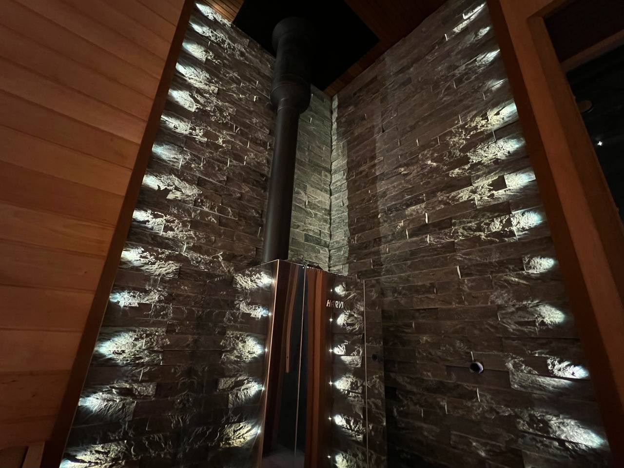 Парная в Лисьем носу с анатомическим пологом и можжевеловым панно, а хромированная печь в свете оптоволокна создает неповторимую атмосферу. SaunaTopMasters